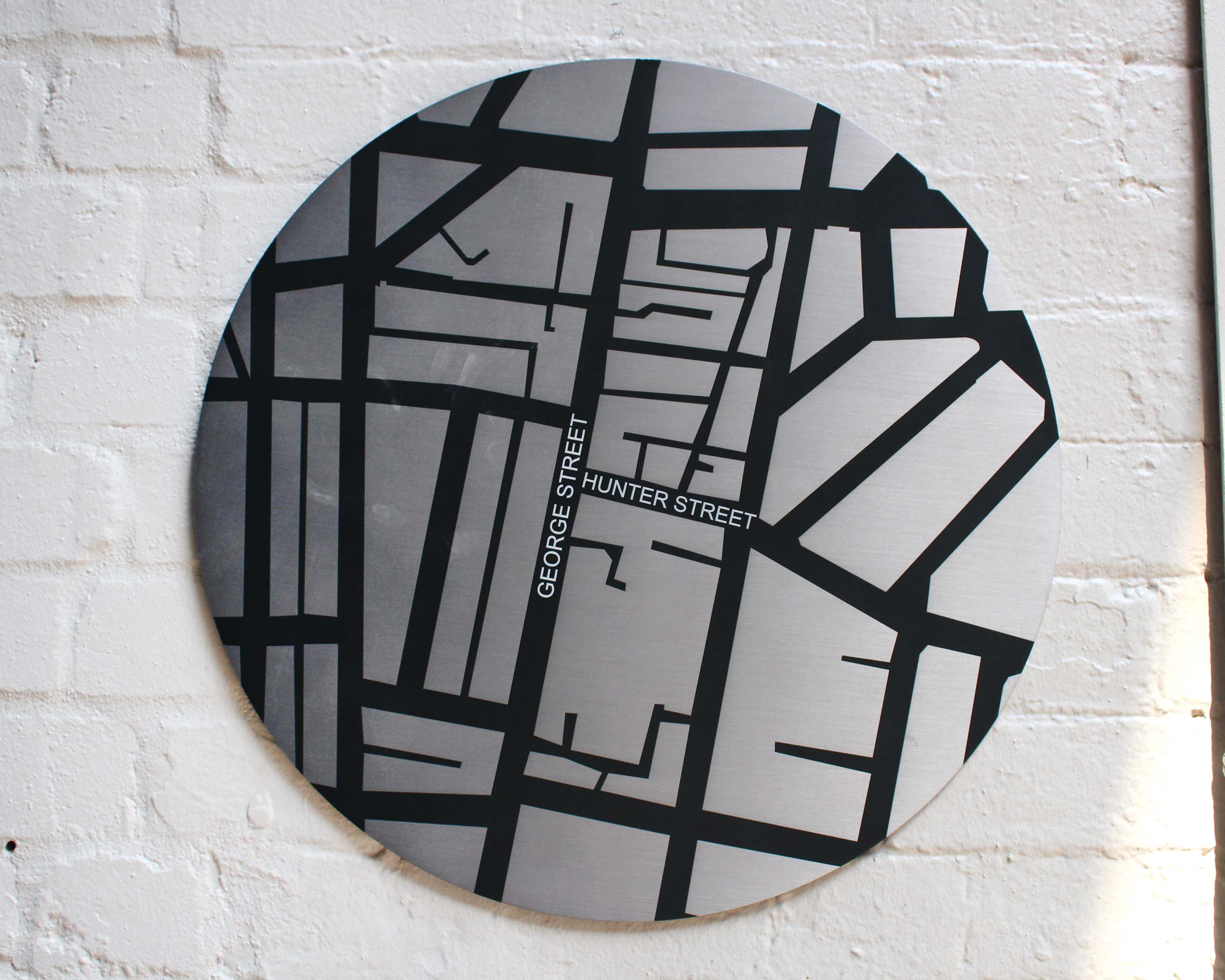 A stainless steel digitally printed external wall plaque showing the road map and intersection of George and Hunter Street.