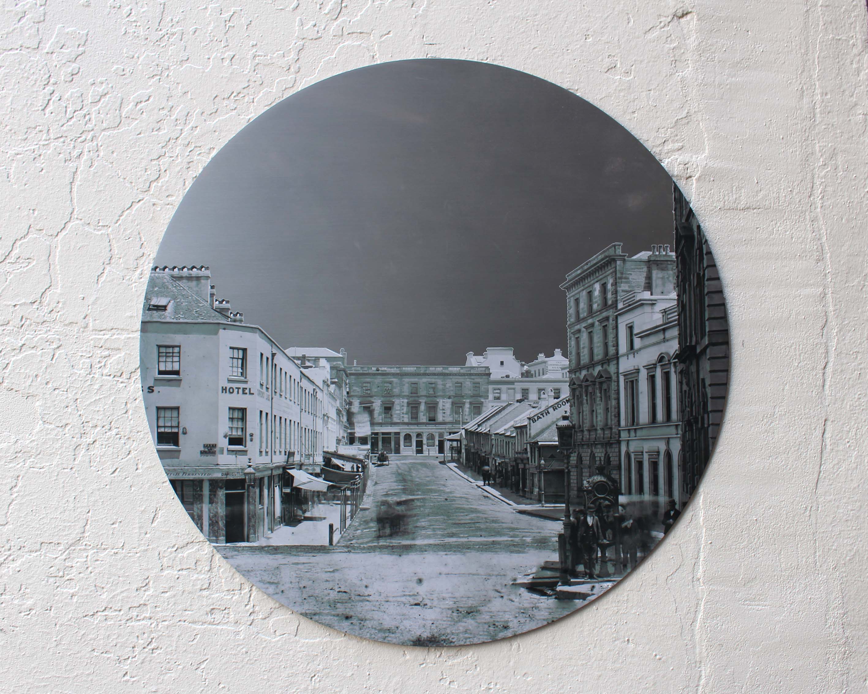 A circular stainless steel digitally printed wall plaque with a black and white historical picture of Hunter Street.