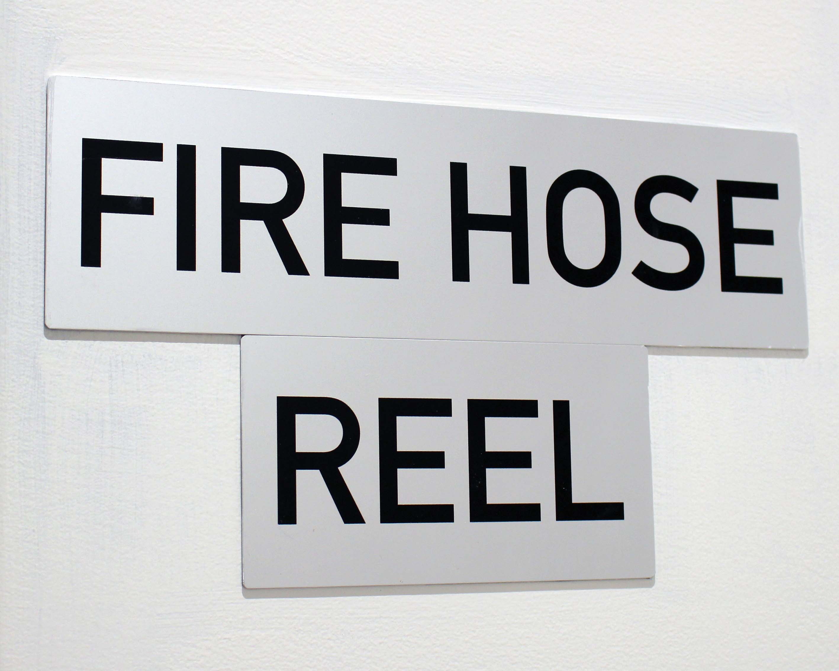 A statutory metal sign that reads FIRE HOSE REEL