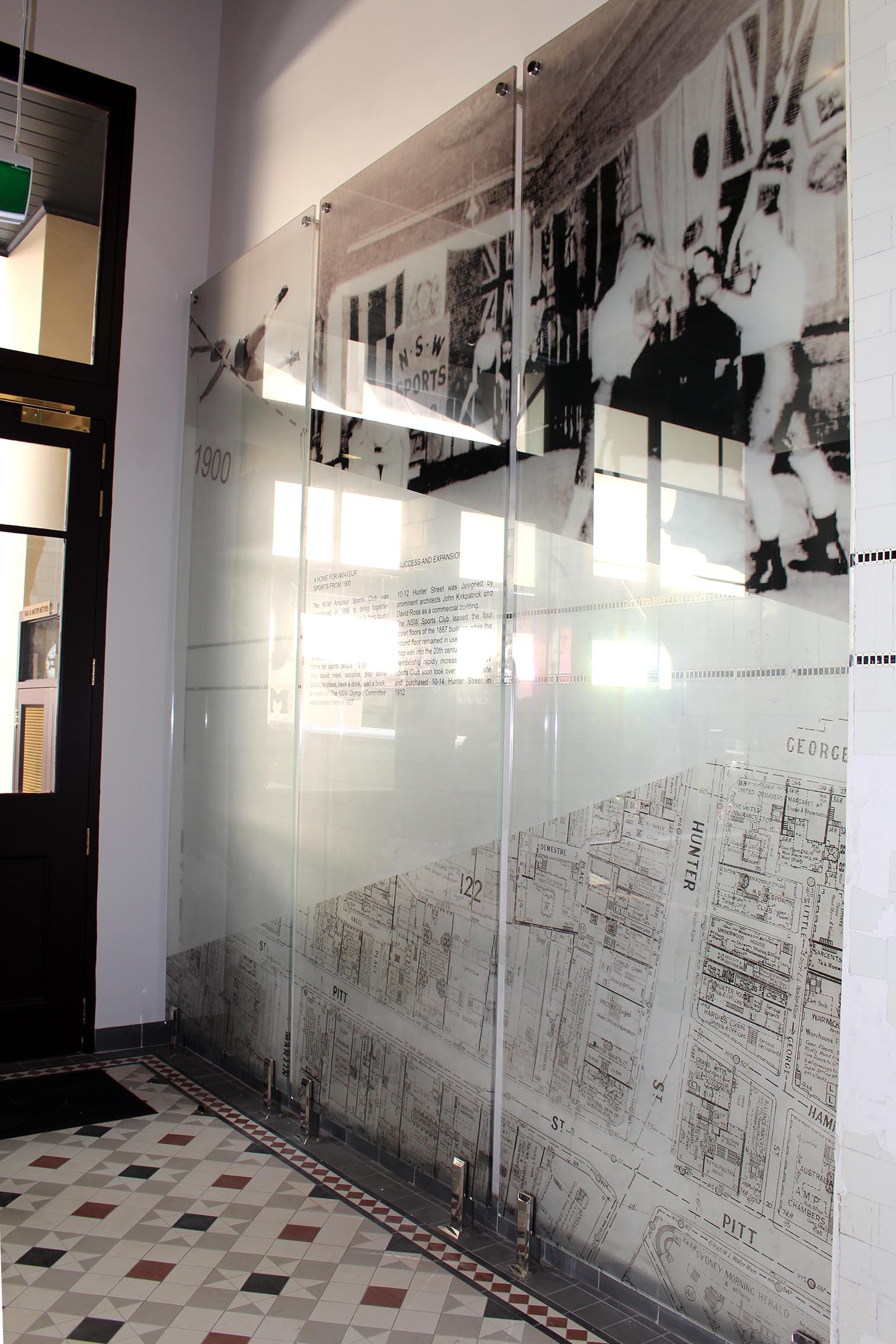 Three large pin mounted glass panels with various black and white images of the NSW Sports club in its heyday.