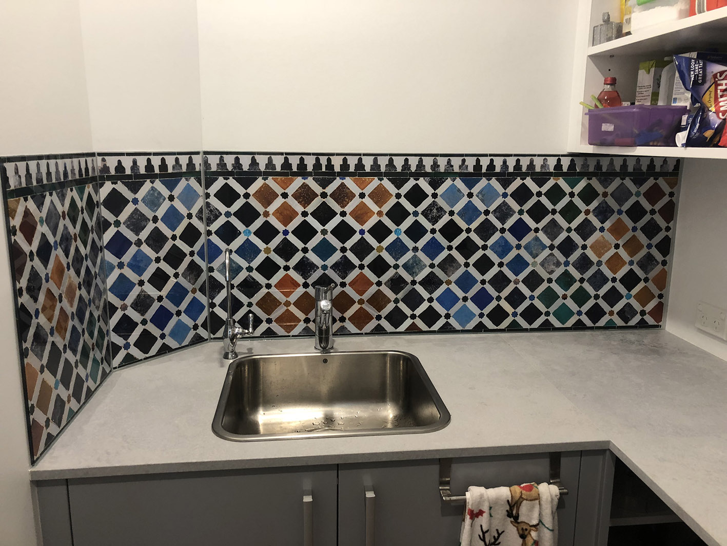 Kitchen glass splashback with coloured geometric shapes.