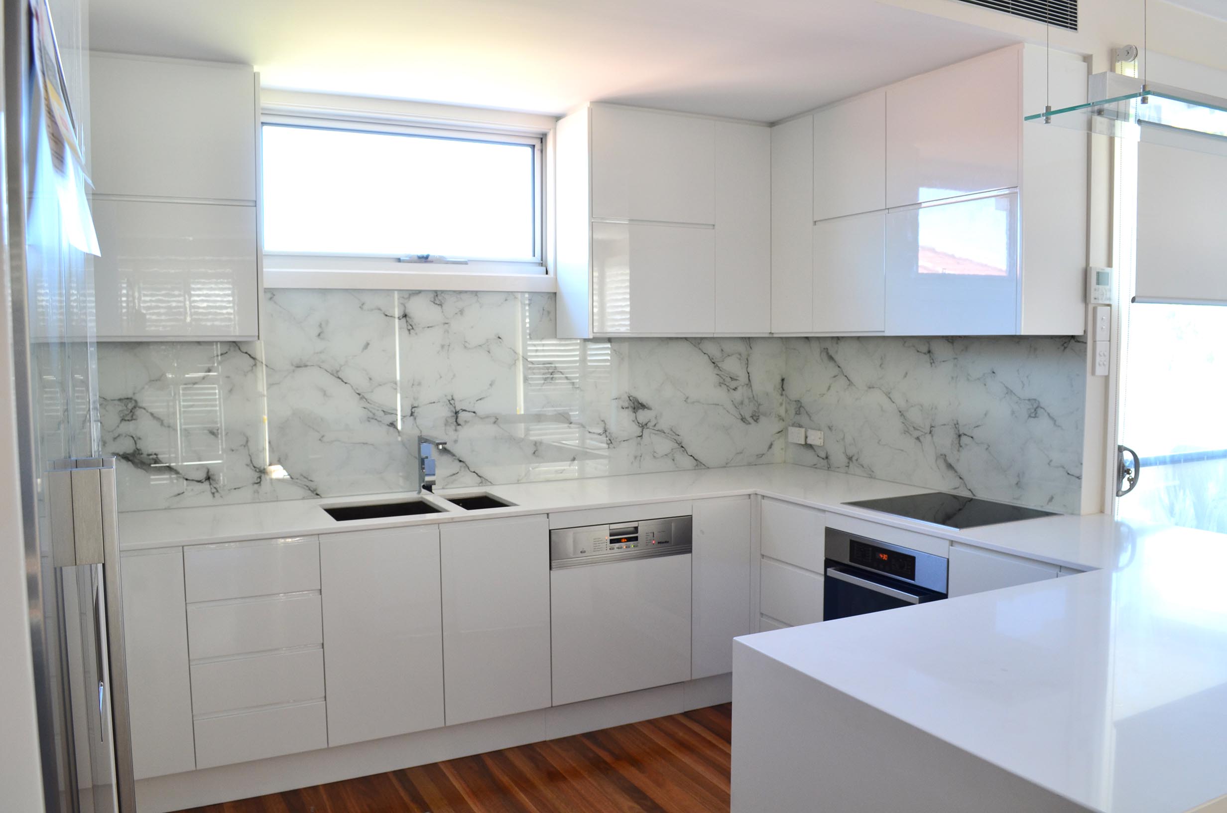 Kitchen with custom glass splashback with marble print.
