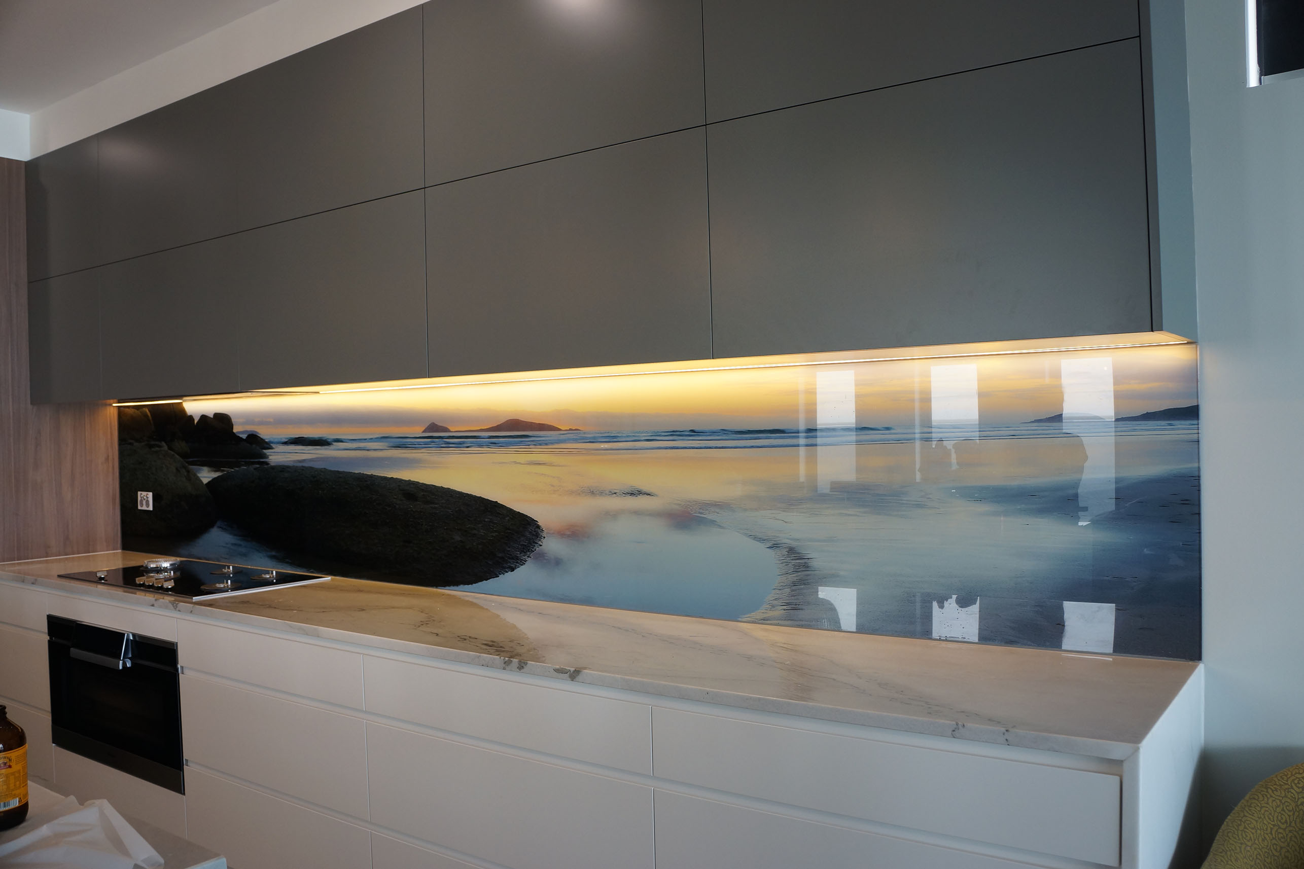 Kitchen with a seascape custom glass kitchen splashback.