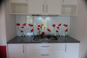 Kitchen featuring a custom printed glass splashback of red flowers.