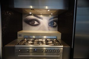 Kitchen featuring a digitally printed glass splashback with a close up photo of a woman's eyes