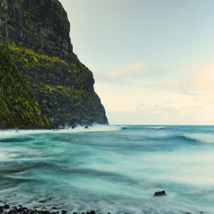 A photo of the sea with a mountain 