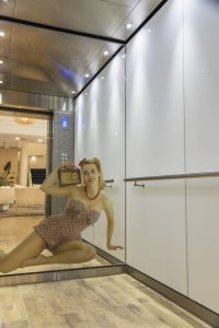 Lift car rear wall feature with beach image printed within mirrored glass