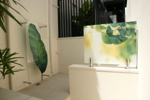 Two outdoor interpretive glass digitally printed graphic panels with garden artwork imagery