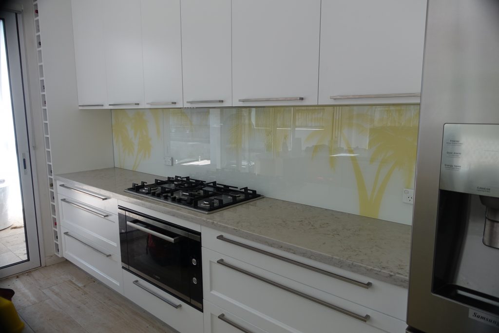 Kitchen with a custom kitchen glass splashback with palm tree imagery