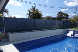 Photo of a pool in the progress of installing a glass fence