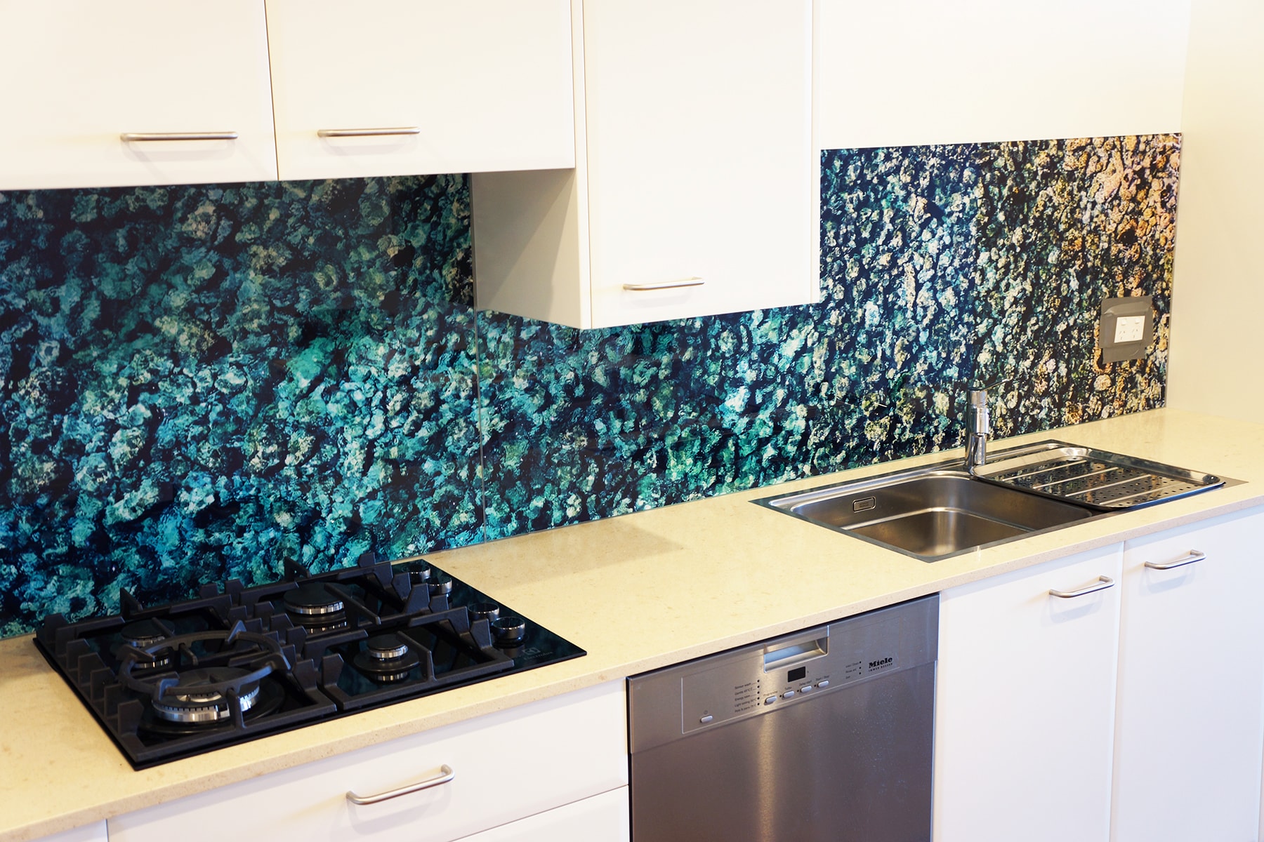 A kitchen with a custom digitally printed splashback with sea and rock imagery
