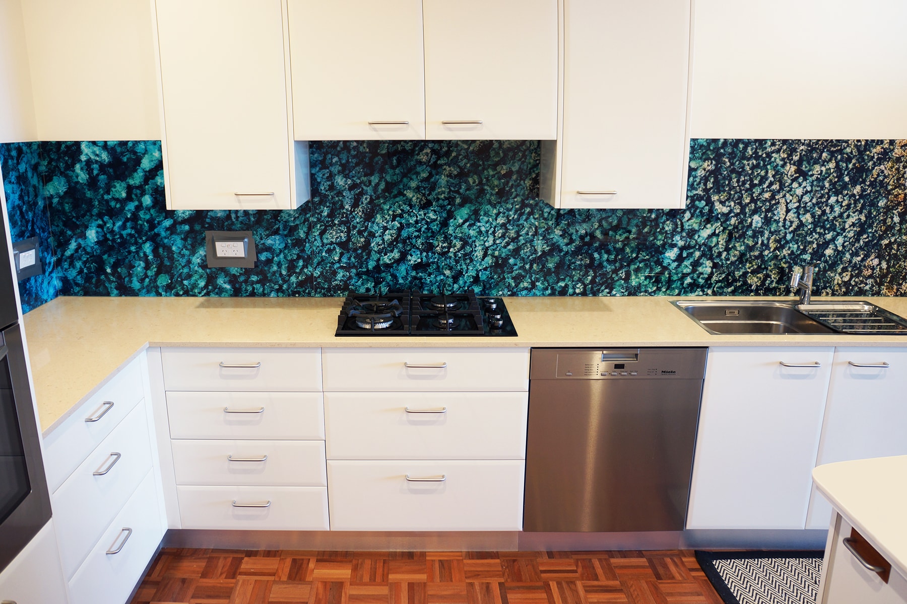 Kitchen with a custom digitally printed glass splashback of sea water and rock imagery