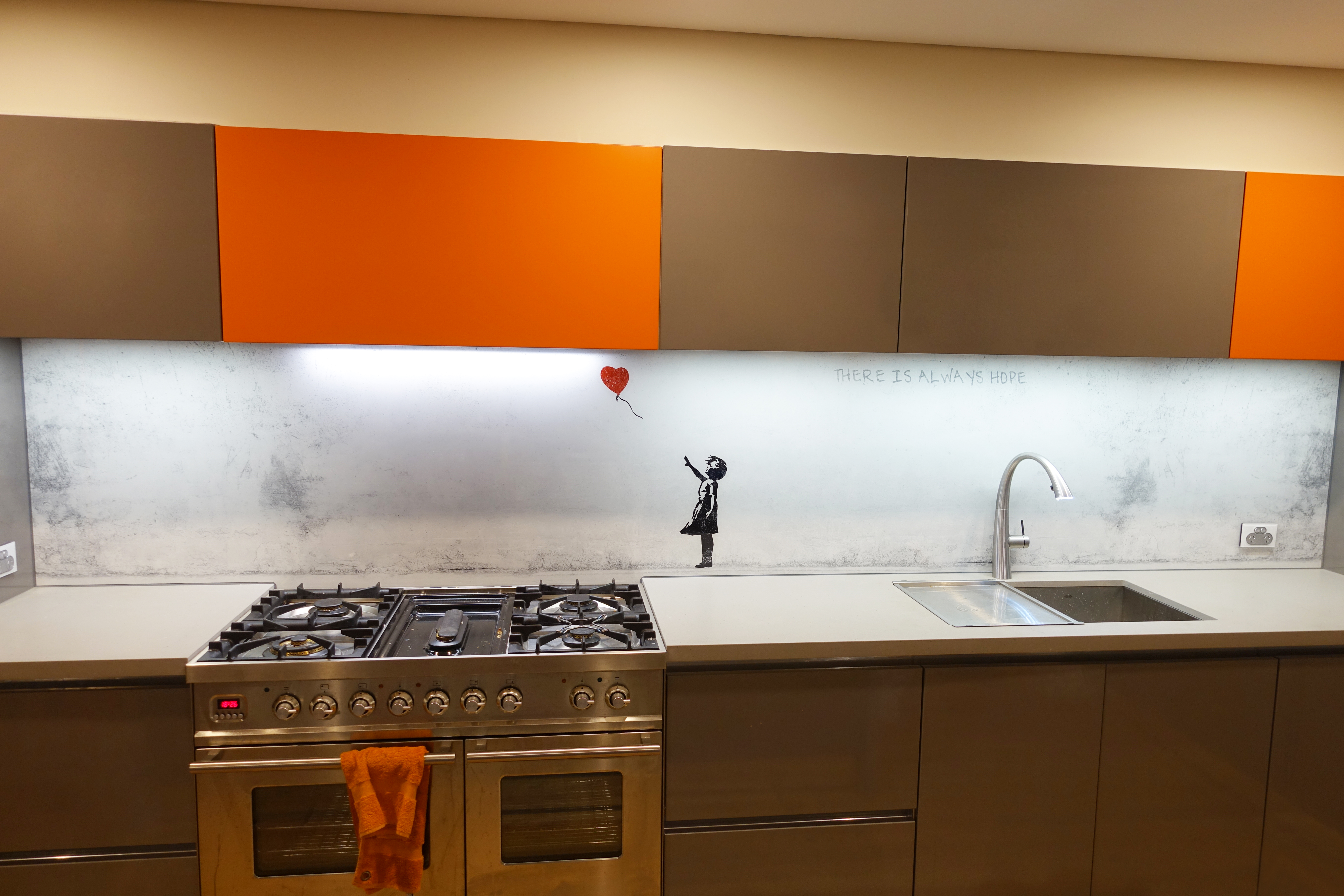 Kitchen with a custom printed glass splashback with Banky's Balloon girl artwork