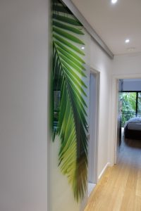 Glass sliding laminated privacy door with palm imagery printed digitally