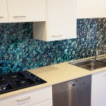 Kitchen with a custom printed glass splashback of sea water and rock imagery
